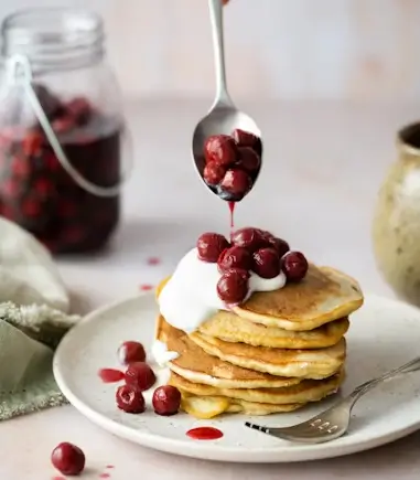 Fluffy pancakes recipe topped with fresh berries and maple syrup