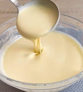 whisking flour eggs and milk to make the best homemade pancakes recipe