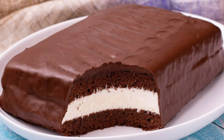 Gâteau Délice chocolate cake topped with shiny dark chocolate ganache, ready to serve.