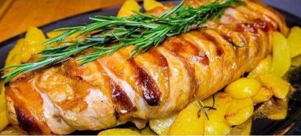 Delicious stuffed turkey roll recipe served with roasted potatoes and rosemary.