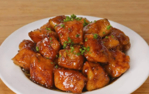 Crispy Honey Garlic Chicken Bites glazed with sticky honey garlic sauce on a white plate