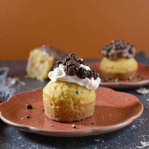 Halloween cupcakes topped with whipped cream and chocolate decorations for a festive dessert