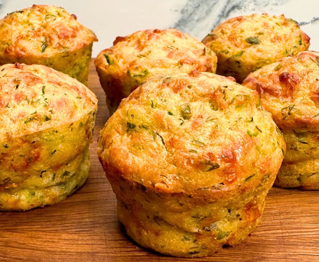 freshly baked zucchini muffins on a wooden board