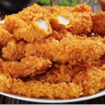 plate of golden crispy chicken strips recipe served with sauce