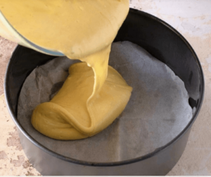 Batter being poured into a cake pan for lemon limoncello cake recipe