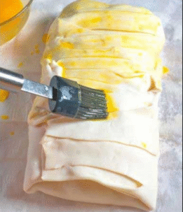salmon wrapped in puff pastry brushed with egg wash before baking