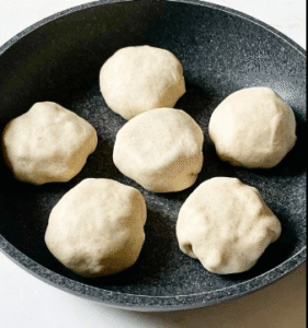 Dough balls resting in a pan for quick pan-fried focaccia