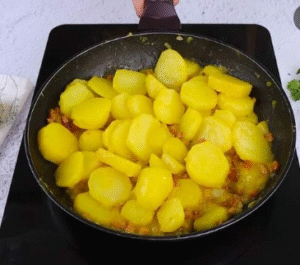 potato gratin recipe adding sliced potatoes to pan