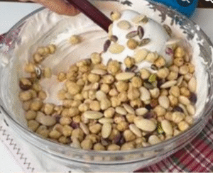Mixed nuts gently folded into white nougat mixture.