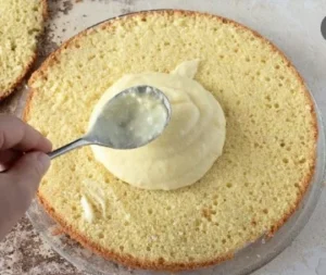 Spreading creamy lemon frosting over cake layers