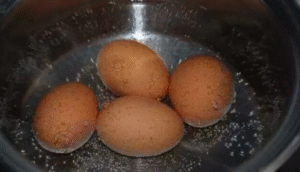 Eggs boiling in salted water for easy peeling