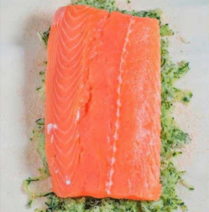raw salmon fillet placed over a bed of shredded zucchini for puff pastry salmon