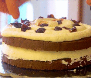 Layering the Black Forest Cake with Cream and Cherries
