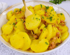 potato gratin recipe pouring creamy cheese sauce over potatoes