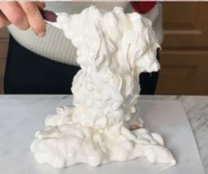 Stretchy white nougat being transferred onto wafer sheets.