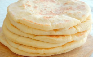 Stack of soft homemade pita breads with a fluffy texture.
