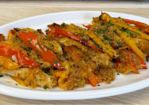Baked chicken strips with peppers served on a plate