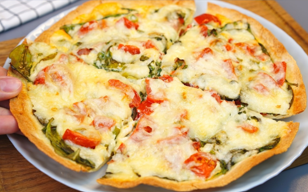 Baked tortilla with spinach and eggs sliced and ready to serve