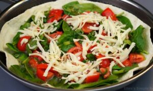 Mozzarella cheese sprinkled on tortilla before baking