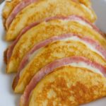 Spreading crepe batter in a non-stick pan for cheese and ham crepes recipe