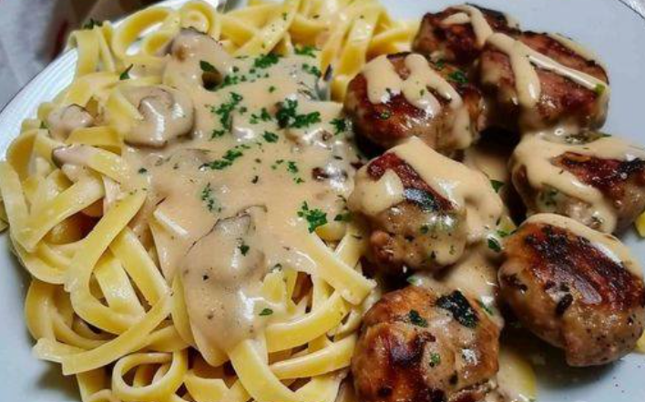 tagliatelle with mushroom sauce and meatballs served hot