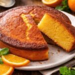 super moist orange sponge cake sliced on plate with fresh orange slices
