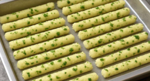Crispy baked potato sticks on tray before oven