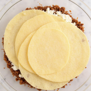 Preparing cheesy beef tortilla bake layers with minced meat and mozzarella