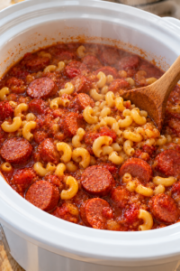 Dry macaroni stirred into hot tomato sauce for slow cooker sausage pasta