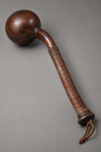 Ball-headed war club with a polished wooden head and stitched leather handle