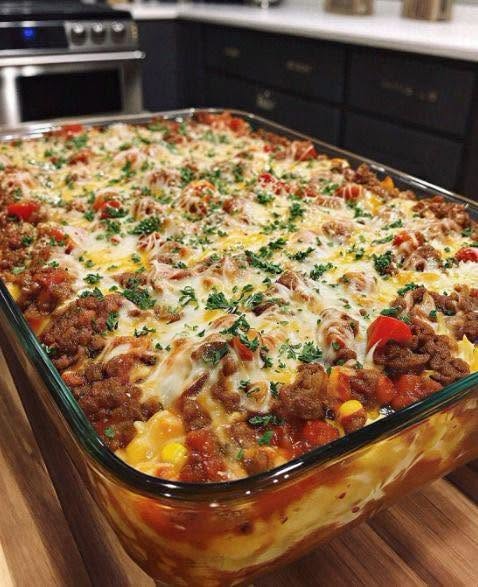Cheesy ground beef casserole with pasta, peppers, corn, and melted cheese