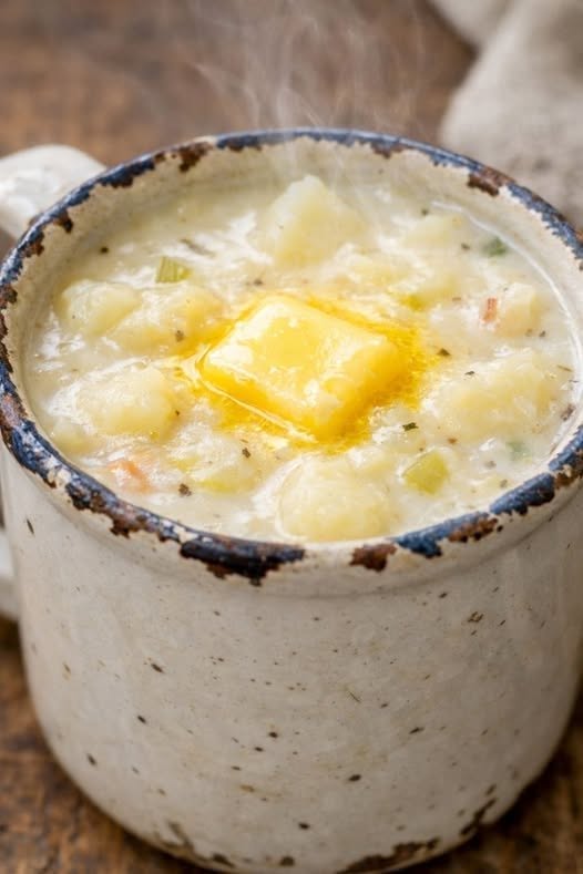 Creamy Potato Soup with tender potato chunks, fresh herbs, black pepper, and melting butter