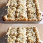 Apple slab pie cut into squares in a rectangular pan, with flaky pastry and visible apple filling.