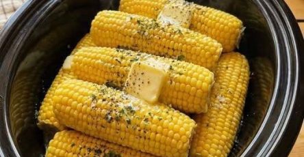 Slow cooker corn on the cob topped with melting butter, herbs, and black pepper.