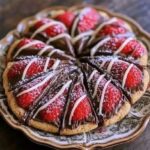 Sliced chocolate strawberry tart topped with fresh strawberries and white chocolate drizzle.