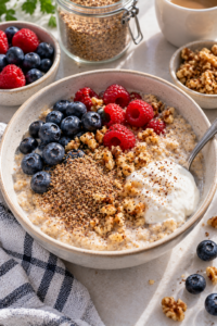 Healthy foods and ground seeds illustrating realistic flaxseed benefits within a balanced diet.