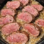 Sliced slow cooker beef tenderloin in garlic butter sauce