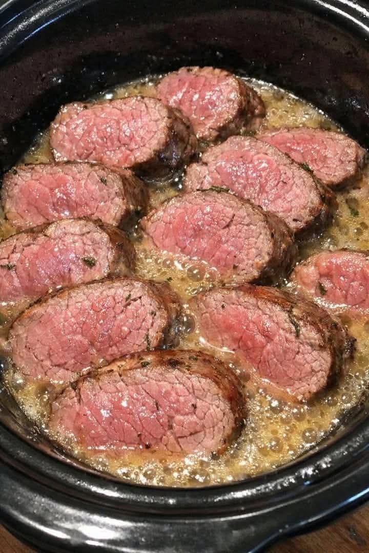 Sliced slow cooker beef tenderloin in garlic butter sauce