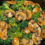 Garlic butter broccoli and mushrooms cooked in a cast-iron skillet