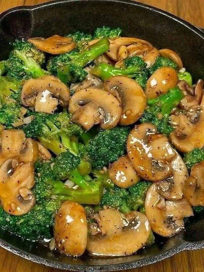 Garlic butter broccoli and mushrooms cooked in a cast-iron skillet