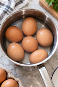 Six eggs covered with cold water while preparing Perfect Hard Boiled Eggs