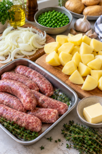 Sausages, potatoes, onions, and peas prepared for bangers and mash.