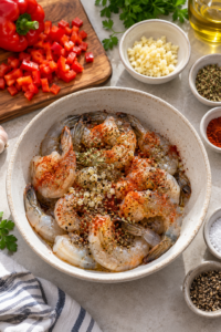 Raw seasoned shrimp prepared for creamy garlic shrimp pasta.