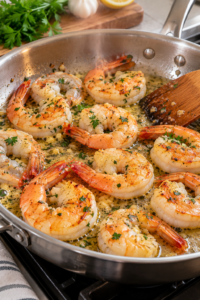 Garlic butter shrimp cooking in a skillet until the flesh turns opaque