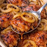 Chicken thighs and sliced onions prepared for 3-Ingredient Charleston Chicken.