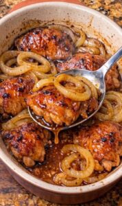 Chicken thighs and sliced onions prepared for 3-Ingredient Charleston Chicken.