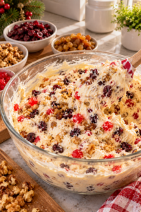 creamy no-bake Christmas dessert being prepared with fruit and nuts