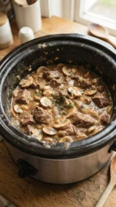 Beef and mushrooms covered in sauce for Slow Cooker 4-Ingredient Mushroom Beef Tips.
